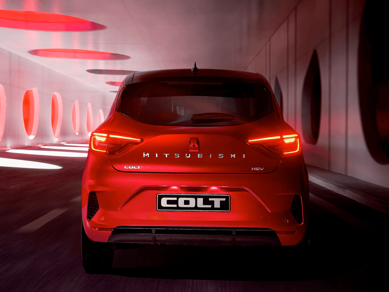En röd Mitsubishi Colt kör genom en tunnel, sedd bakifrån