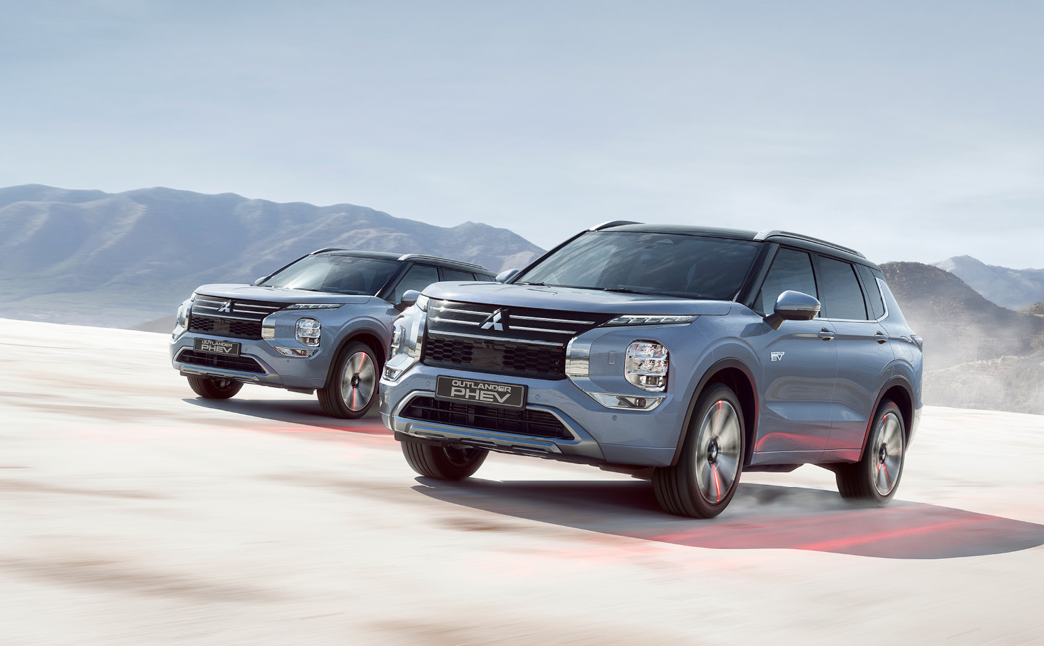 Två Mitsubishi Outlander kör genom en öken