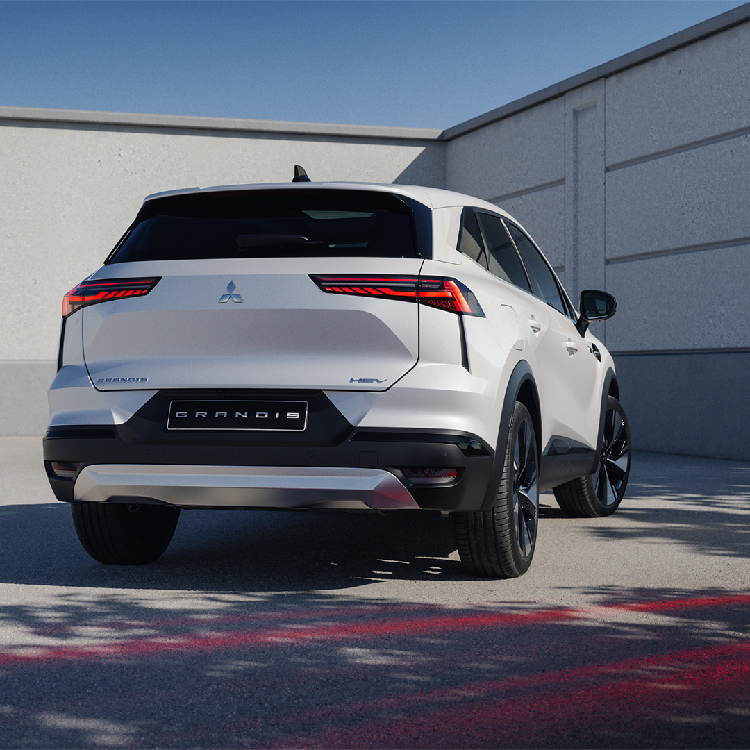 En svar och en röd ASX kör på vägen