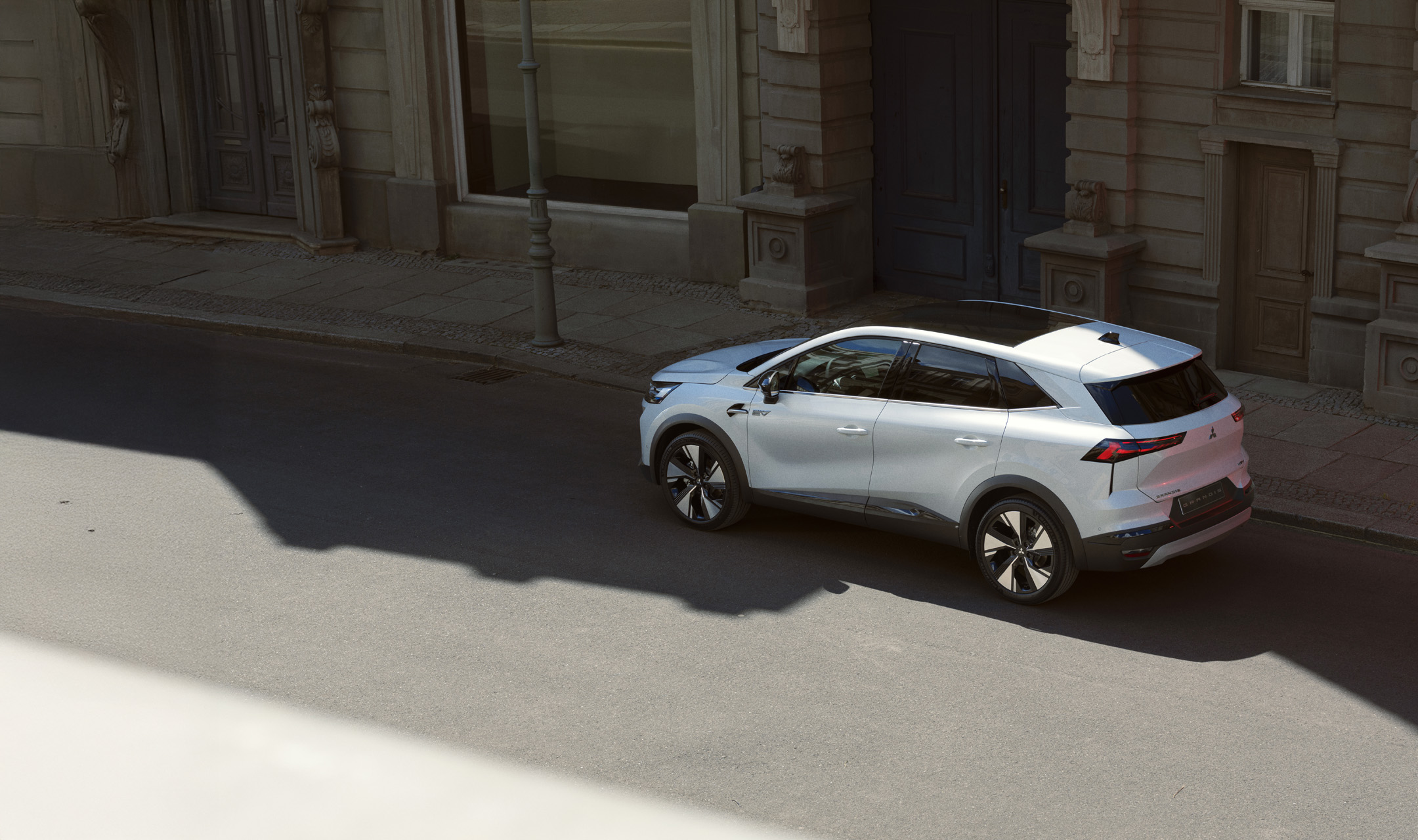 En röd Mitsubishi Colt kör genom en tunnel, sedd bakifrån